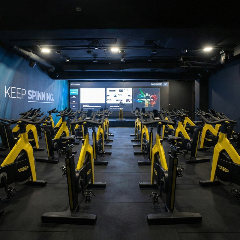 Premium indoor cycling studio at Eliteness Villeverte with immersive lighting and high-performance RPM bikes
