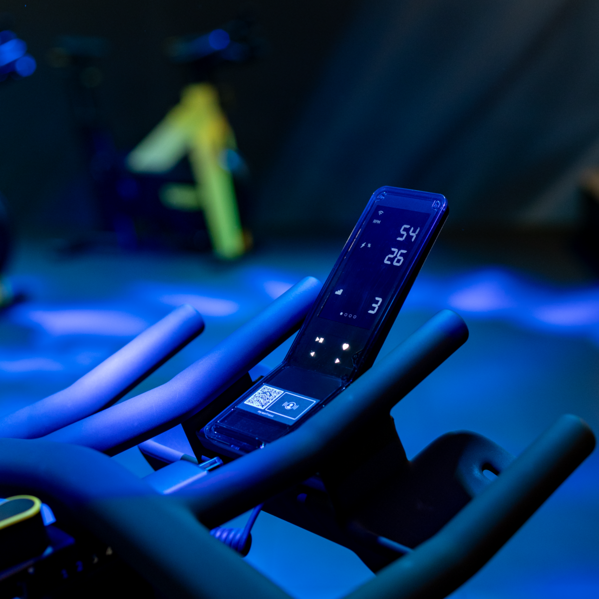 Premium indoor cycling studio at Eliteness Villeverte with immersive lighting and high-performance RPM bikes